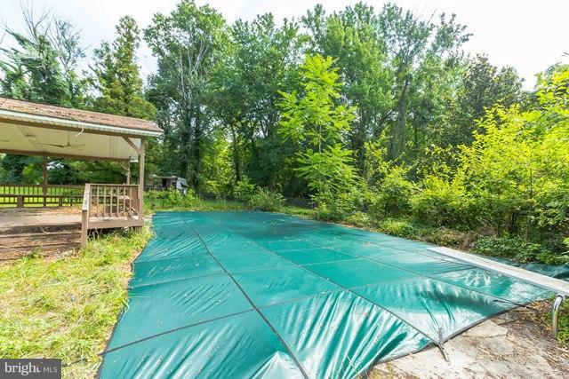 5865 Solomons Island Road Tracys Landing, MD 20779 - Photo 26 of 29 a view of a backyard with lawn chairs under an umbrella