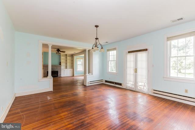 5865 Solomons Island Road Tracys Landing, MD 20779 - Photo 6 of 29 an empty room with wooden floor chandelier and windows