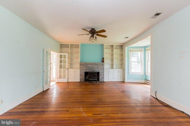 5865 Solomons Island Road Tracys Landing, MD 20779 - Photo 7 of 29 a view of a livingroom with a fireplace a ceiling fan and windows