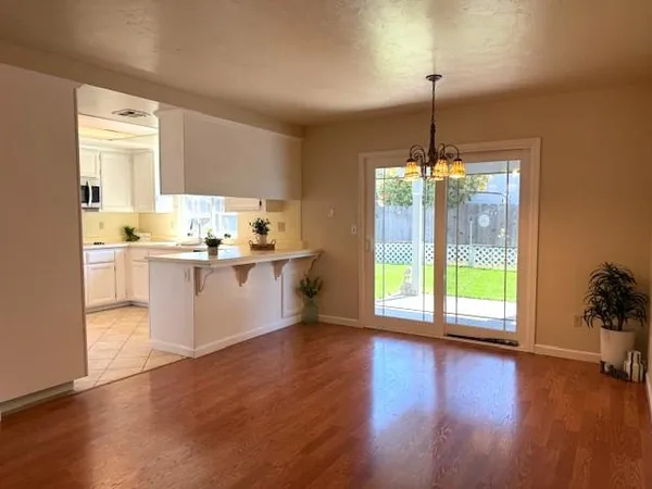 a kitchen with kitchen island a sink wooden floor and a chandelier