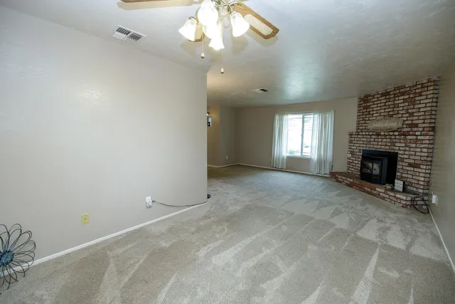an empty room with a fireplace and fan