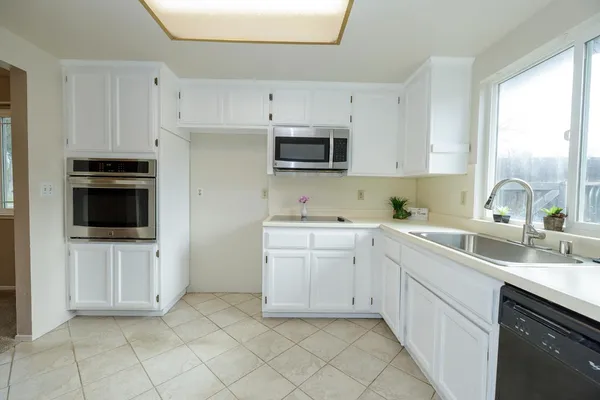 a kitchen with white cabinets and white appliances