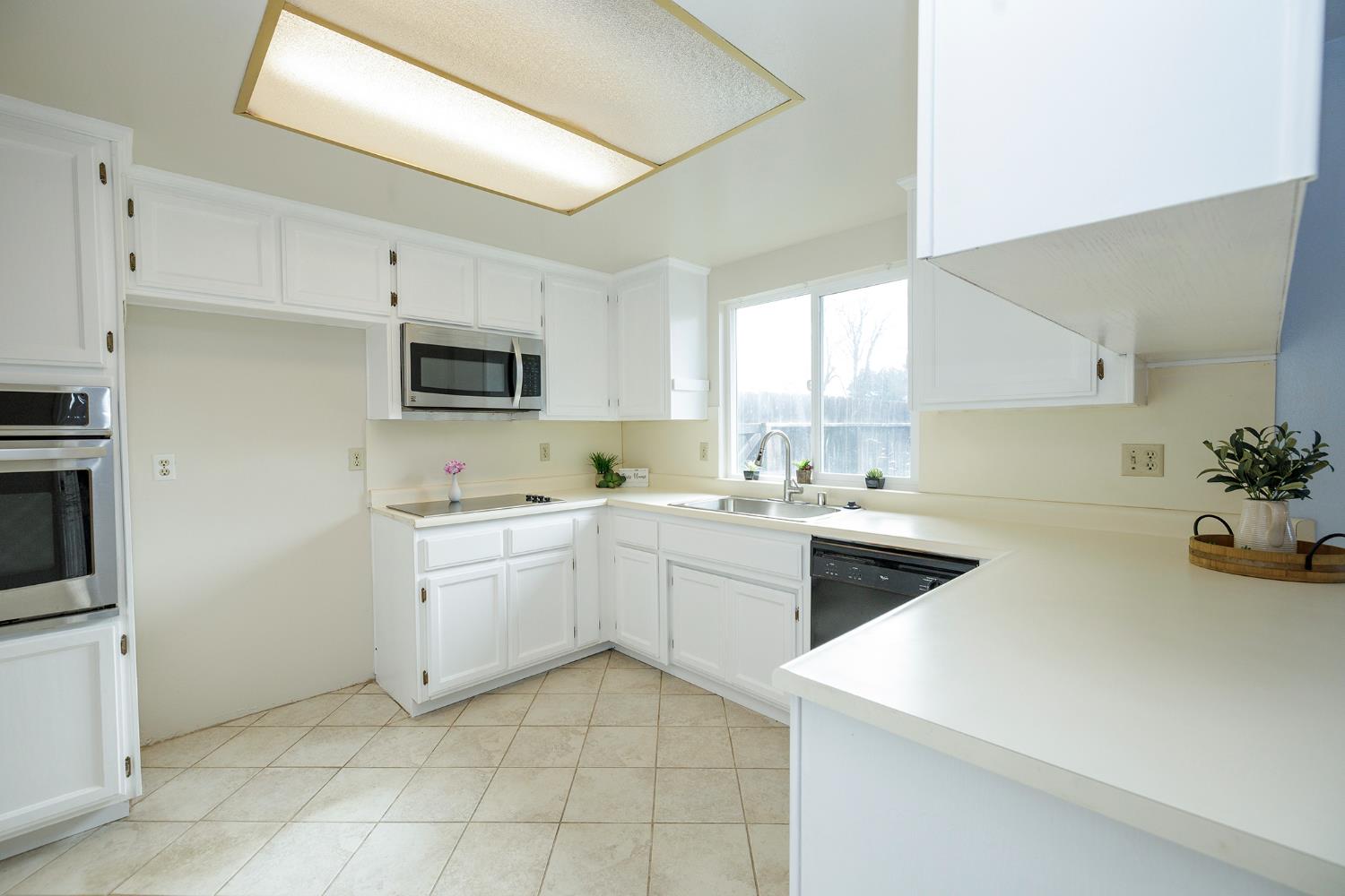 495 Valdapena Way Escalon, CA 95320 - Photo 16 of 43 a kitchen with a sink a stove top oven and white cabinets