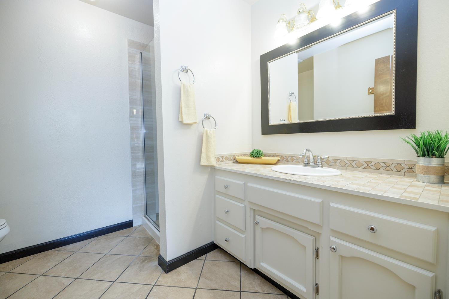 495 Valdapena Way Escalon, CA 95320 - Photo 23 of 43 a bathroom with a granite countertop sink and a mirror