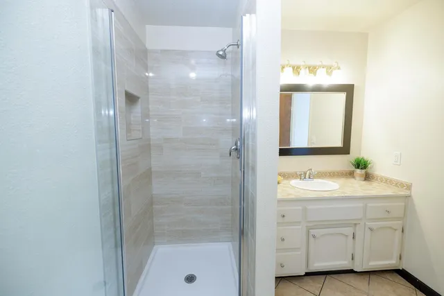 a bathroom with a shower sink and mirror