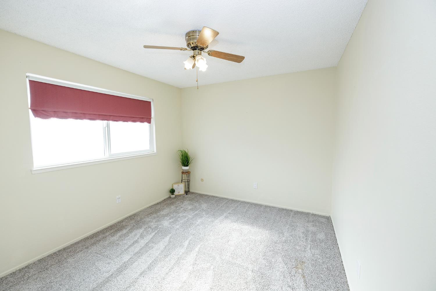 495 Valdapena Way Escalon, CA 95320 - Photo 26 of 43 an empty room with a window and a ceiling fan