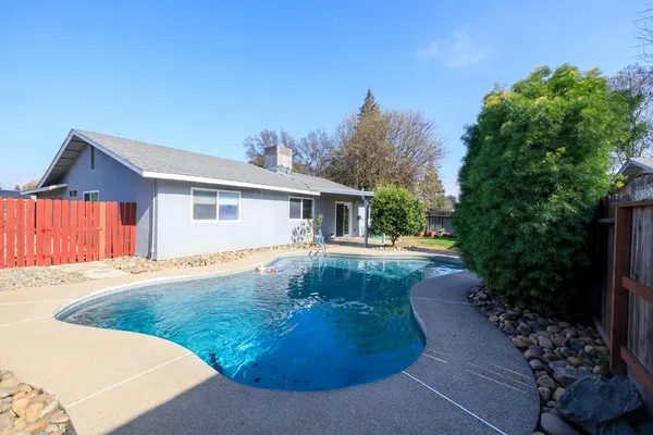 a view of a house with backyard and sitting area