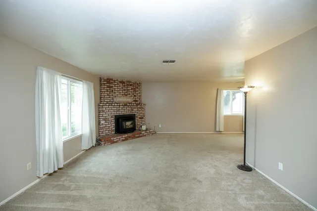 an empty room with windows and a fireplace