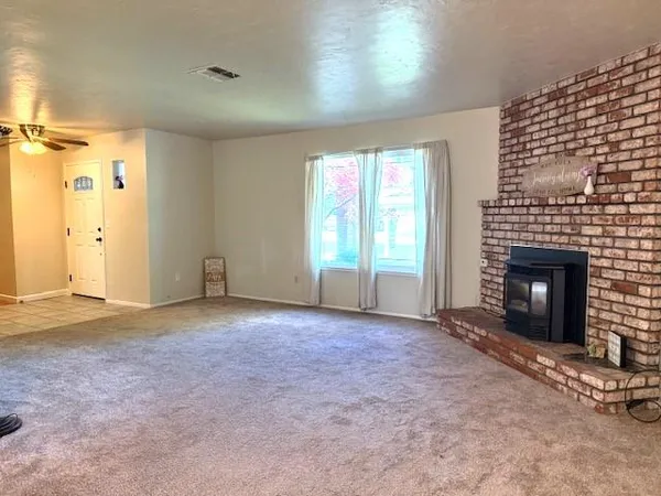 an empty room with windows and fireplace