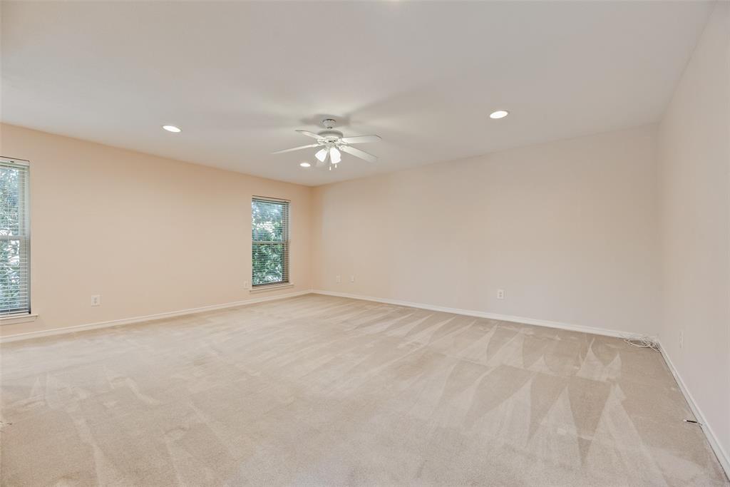 4988 Thunder Road Dallas, TX 75244 - Photo 16 of 32 Spacious primary room featuring neutral carpeting, light-toned walls, and multiple windows
