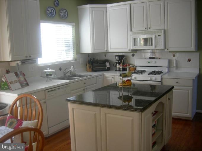 46815 Willowood Place Sterling, VA 20165 - Photo 12 of 22 a kitchen with stainless steel appliances granite countertop a sink stove and cabinets