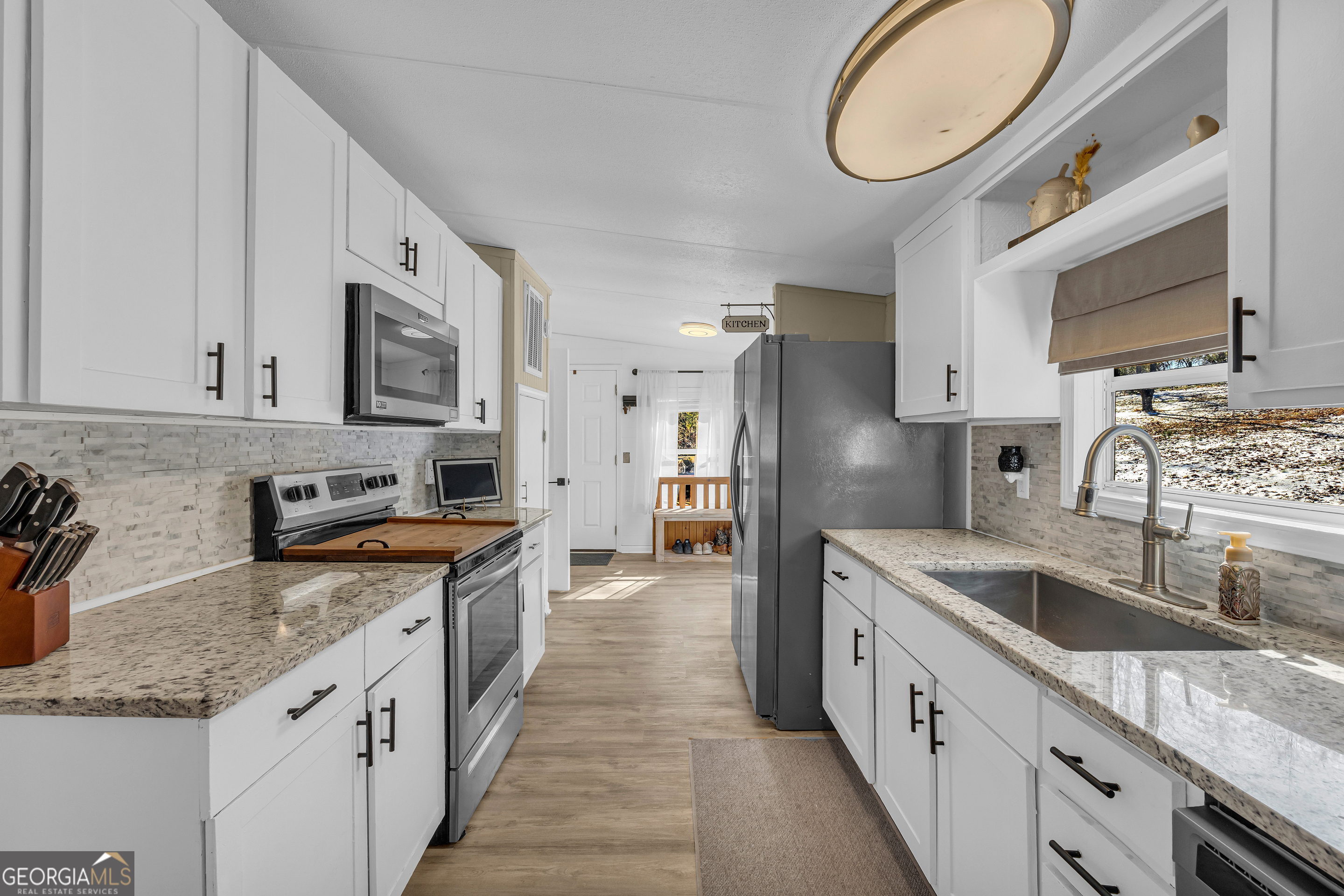 3656 Candler Road Pendergrass, GA 30567 - Photo 21 of 34 a large kitchen with stainless steel appliances granite countertop a sink stove and cabinets