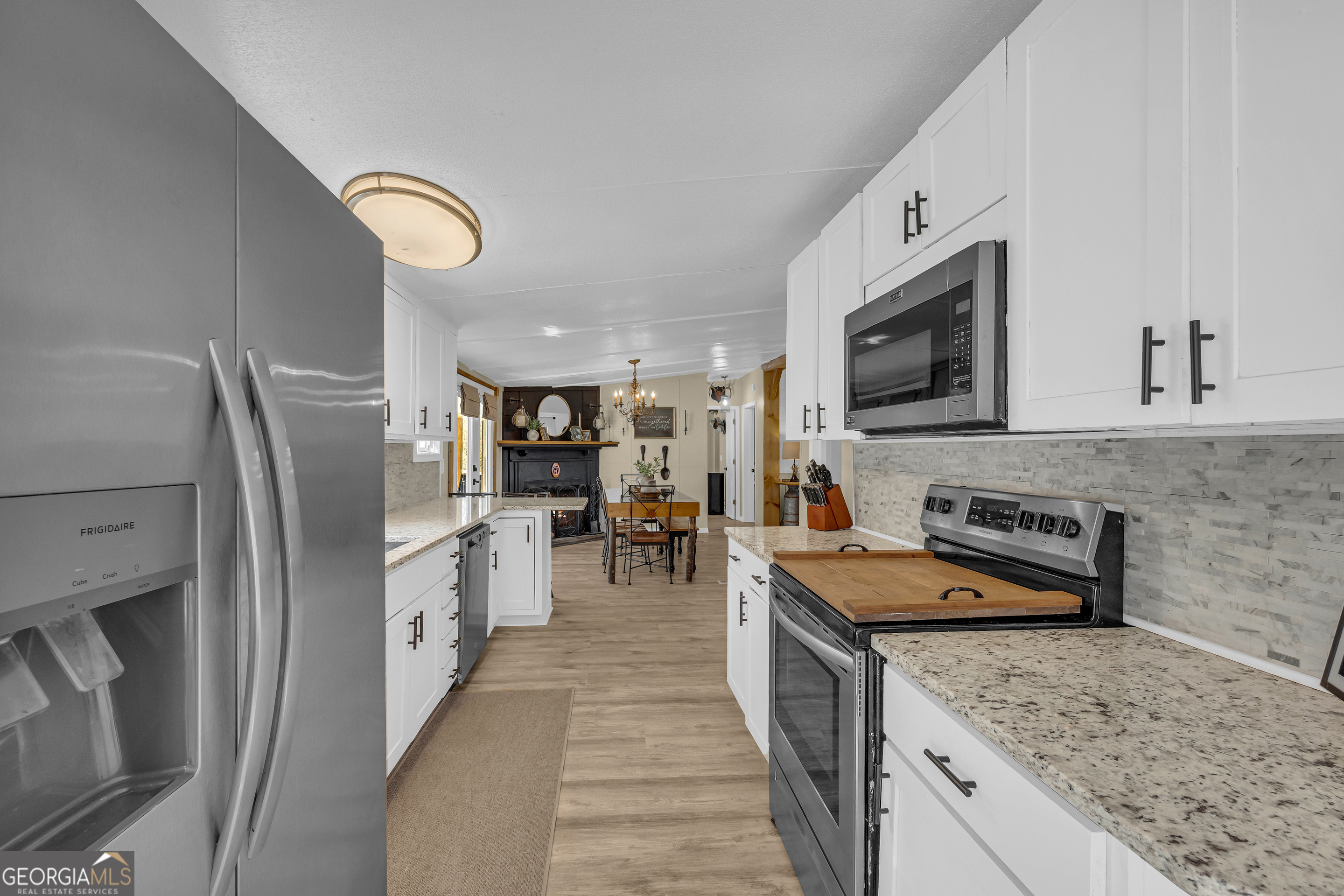 3656 Candler Road Pendergrass, GA 30567 - Photo 23 of 34 a large kitchen with stainless steel appliances granite countertop a stove refrigerator and a sink