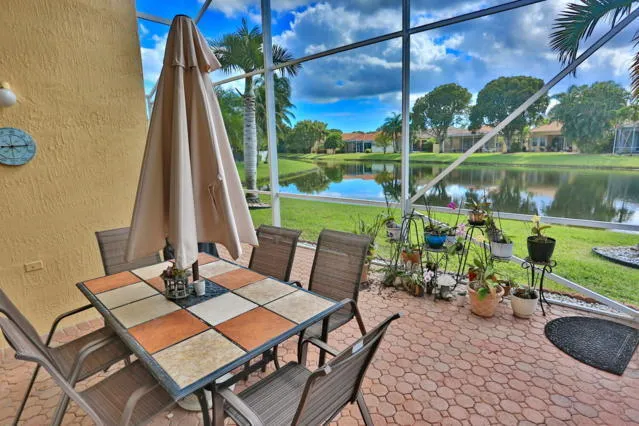 a view of a patio with table and chairs potted plants with floor to ceiling window and wooden floor