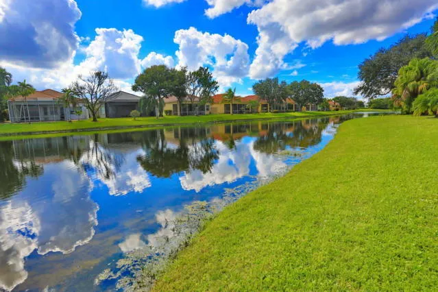 a view of a lake in front of house with a yard and outdoor seating