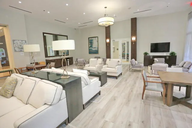 a living room with furniture a flat screen tv and a chandelier