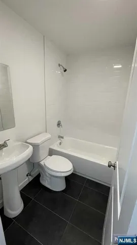 a view of an empty room with wooden floor and stairs