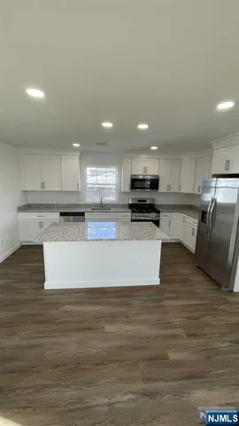 a kitchen with stainless steel appliances a stove a sink and a microwave