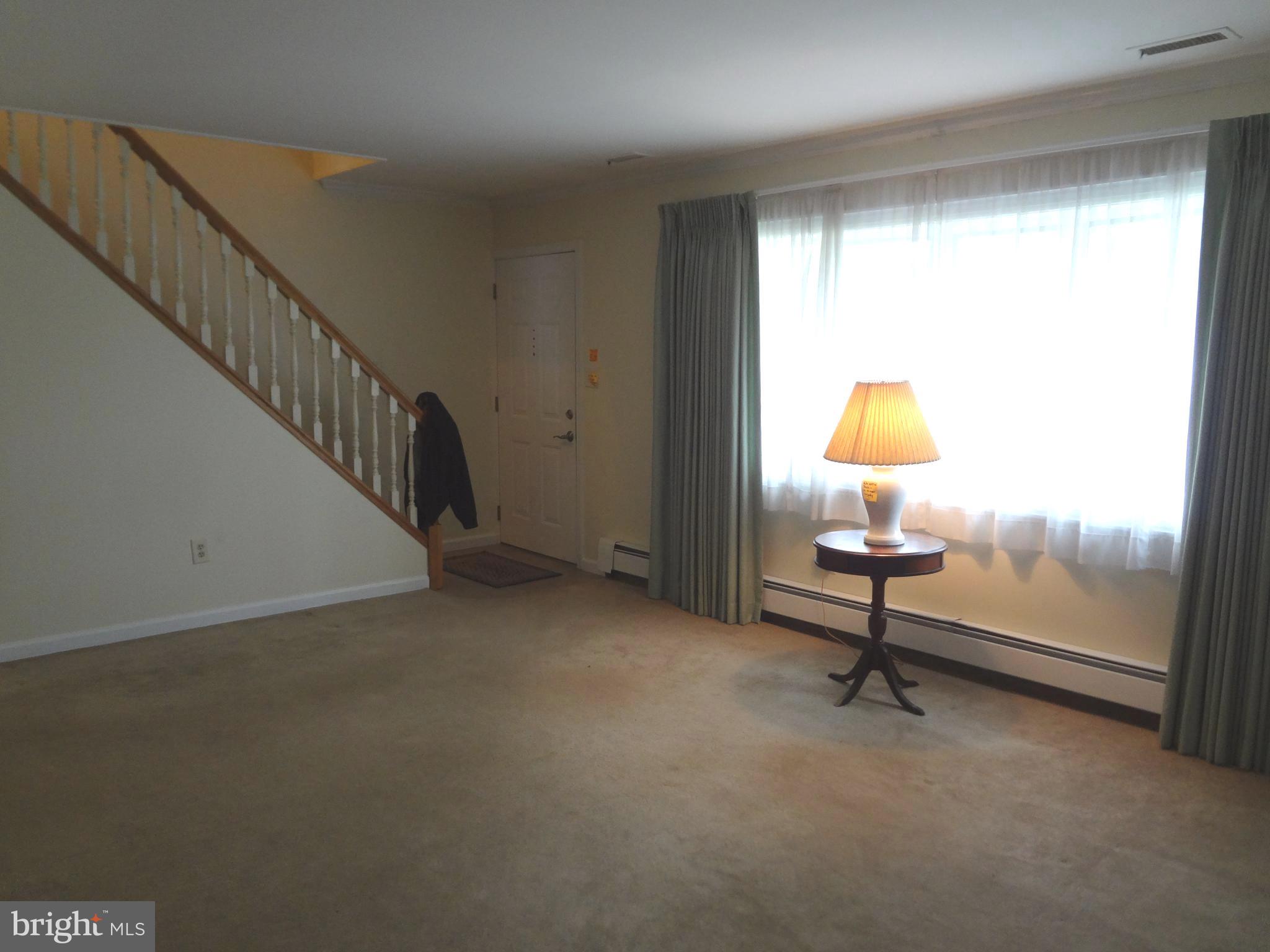 91 Cardinal Road Levittown, PA 19057 - Photo 3 of 26 a view of an empty room with wooden floor and a window