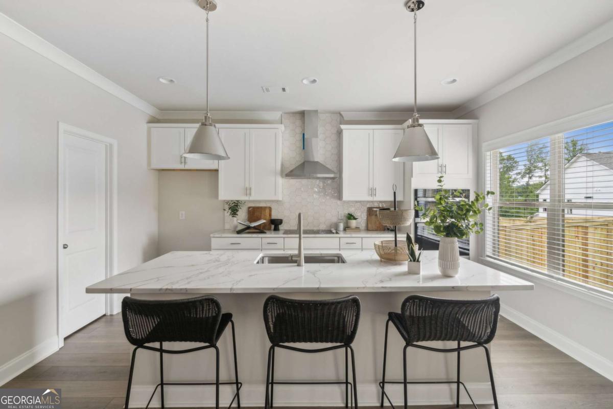 5566 Overview Drive, Unit 25 Flowery Branch, GA 30542 - Photo 9 of 20 a kitchen with granite countertop a table chairs stove and cabinets