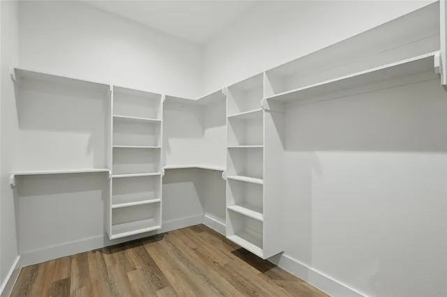 a view of walk in closet with empty racks