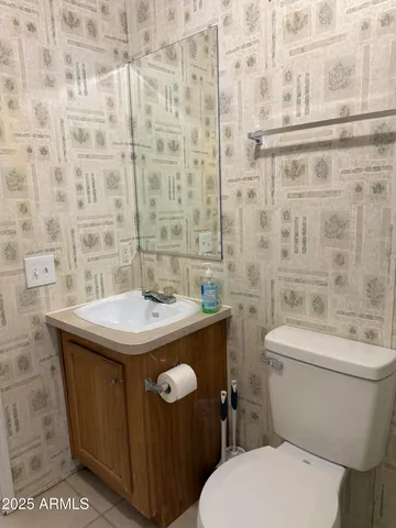 a bathroom with a sink a toilet and a mirror