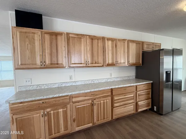 a kitchen with stainless steel appliances granite countertop a refrigerator a sink and dishwasher with wooden floor