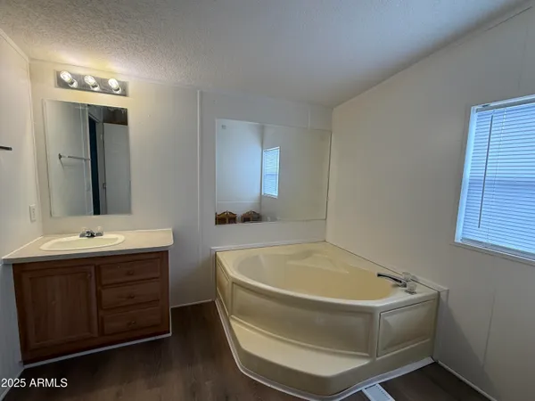 a bathroom with a tub sink and mirror