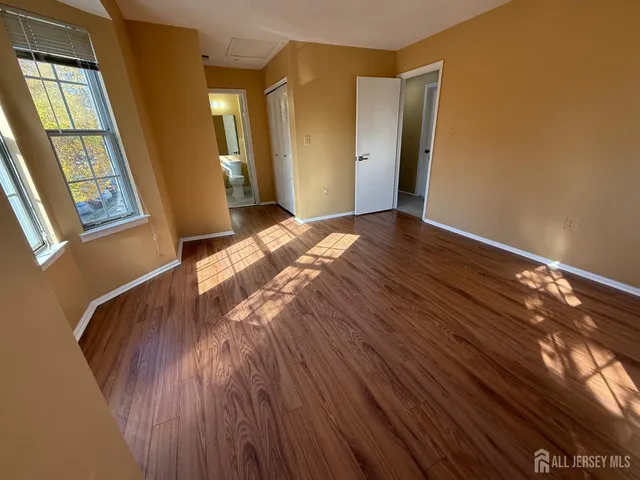 a view of bedroom with window and wooden floor