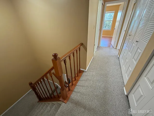 a view of a hallway with wooden floor and stairs