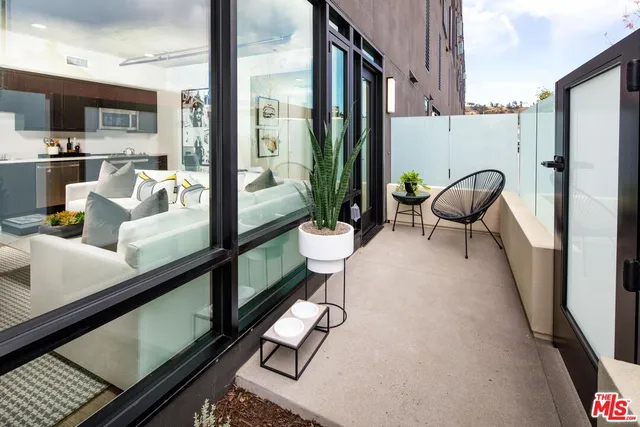 a living room with furniture a flat screen tv and a large window