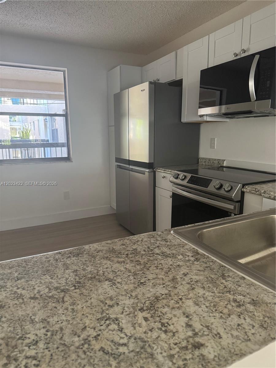 605 Ives Dairy Road, Unit 3067 Miami, FL 33179 - Photo 11 of 28 a kitchen with a stove a refrigerator and a sink