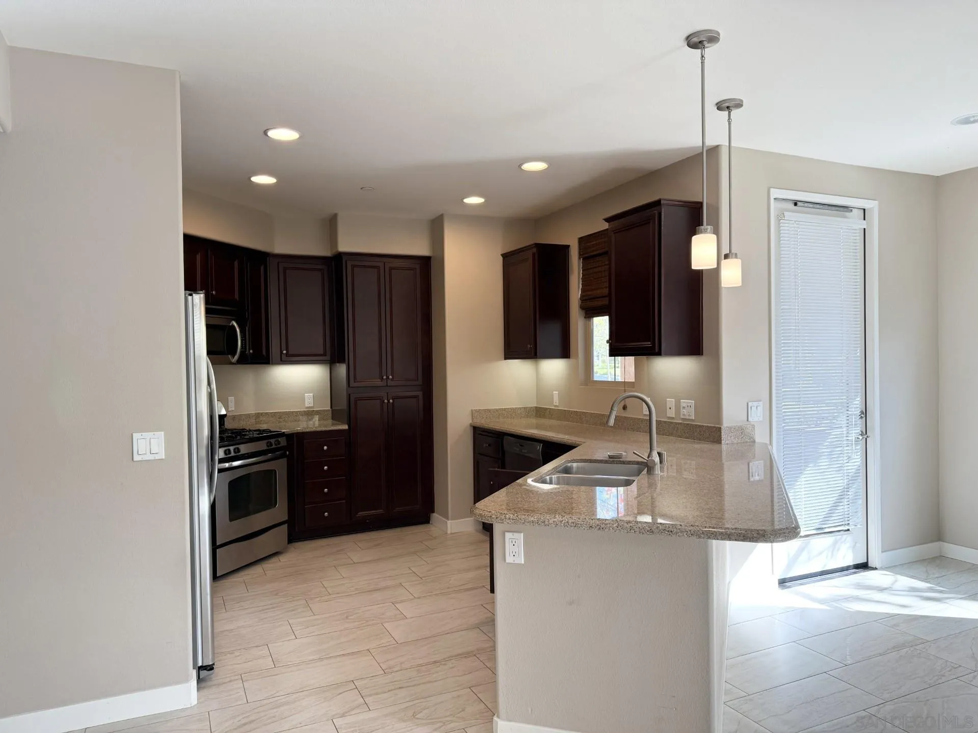 11130 Taloncrest Way, Unit 13 San Diego, CA 92126 - Photo 4 of 11 a kitchen with stainless steel appliances granite countertop a sink a stove and a refrigerator