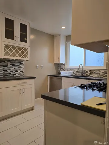 a kitchen with stainless steel appliances granite countertop a sink stove and cabinets