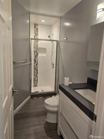 a bathroom with a granite countertop sink toilet and shower