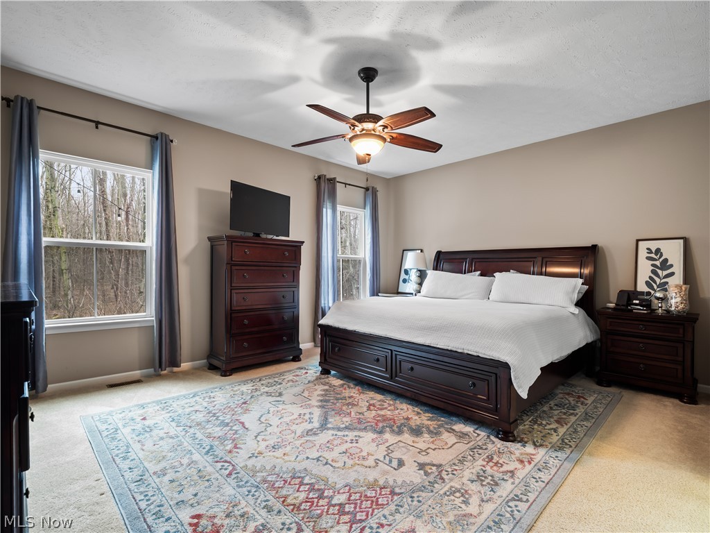 8898 Harvest Ridge Way North Ridgeville, OH 44039 - Photo 14 of 41 Bedroom with light carpet, a ceiling fan, and a textured ceiling