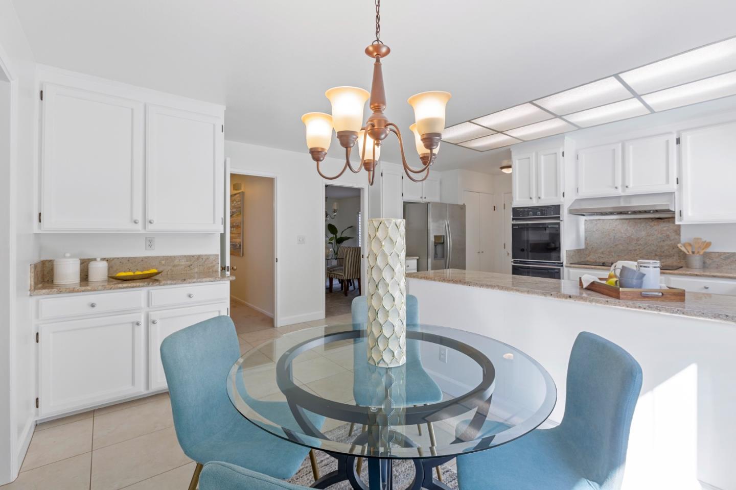 244 Delphi Circle Los Altos, CA 94022 - Photo 19 of 61 a kitchen with stainless steel appliances kitchen island granite countertop a table chairs and a refrigerator