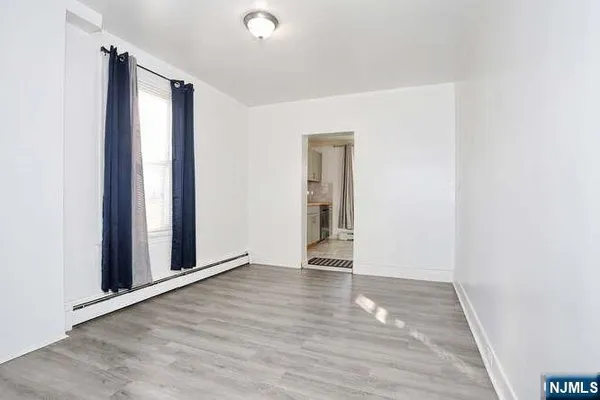 an empty room with wooden floor and a window