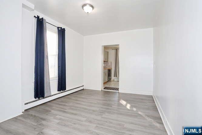 68 Mohawk Avenue, Unit 1 Hawthorne, NJ 07506 - Photo 4 of 21 an empty room with wooden floor and a window
