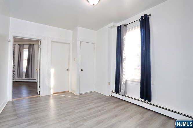 68 Mohawk Avenue, Unit 1 Hawthorne, NJ 07506 - Photo 5 of 21 an empty room with wooden floor and windows