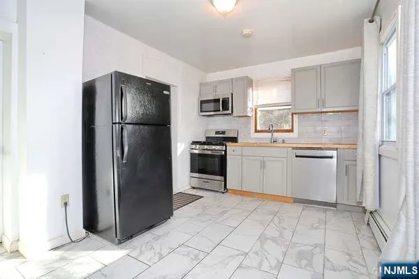 a kitchen with a refrigerator sink and cabinets