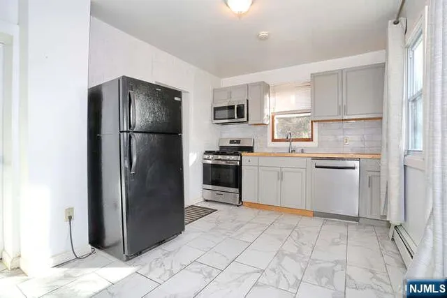 a kitchen with a refrigerator sink and cabinets