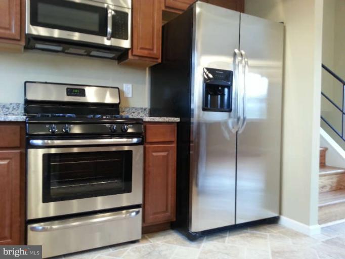 3502 Sedgemoor Road Baltimore, MD 21207 - Photo 14 of 29 a kitchen with stainless steel appliances granite countertop a stove and a microwave