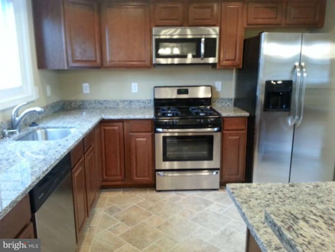 3502 Sedgemoor Road Baltimore, MD 21207 - Photo 4 of 29 a kitchen with stainless steel appliances granite countertop a stove a microwave and a sink