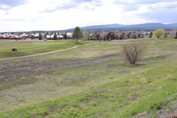 a view of a field with a building in the background