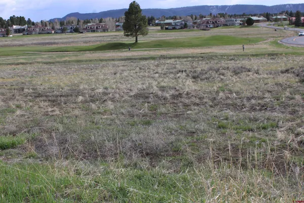 a view of a field with a building in the background
