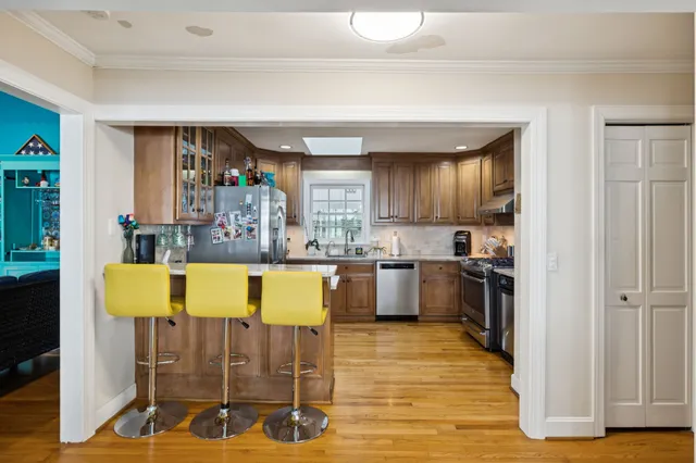 a kitchen with stainless steel appliances granite countertop a stove a sink dishwasher and a microwave oven with wooden cabinets