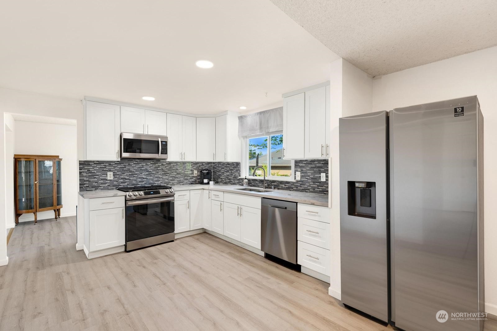 2102 240th Place Southeast Bothell, WA 98021 - Photo 8 of 20 a kitchen with granite countertop stainless steel appliances a refrigerator a stove top oven and sink