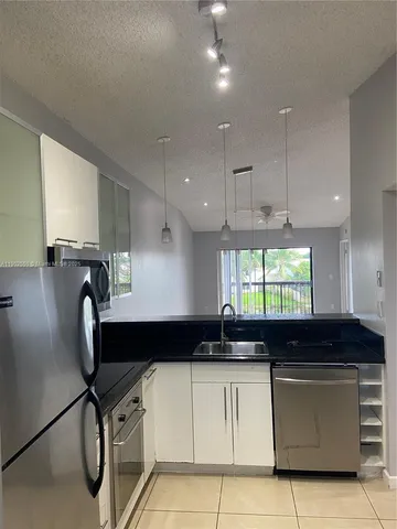 a kitchen with a sink a window stainless steel appliances and cabinets