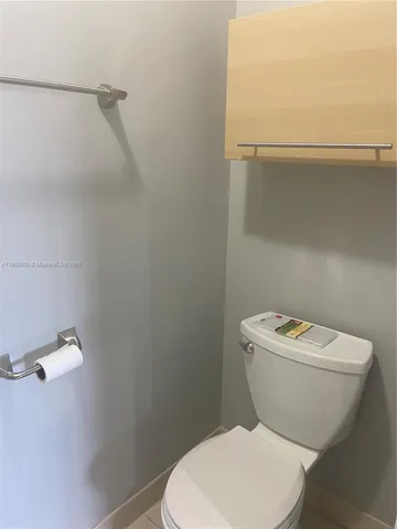 a white toilet sitting next to a white wall